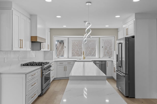 kitchen featuring white cabinets, premium appliances, and a sink