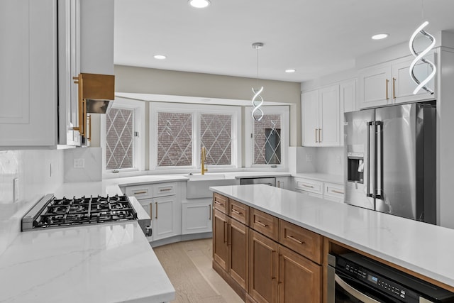 kitchen with white cabinets, recessed lighting, a sink, high end refrigerator, and decorative light fixtures