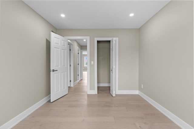 unfurnished bedroom with light wood-style flooring, baseboards, and recessed lighting