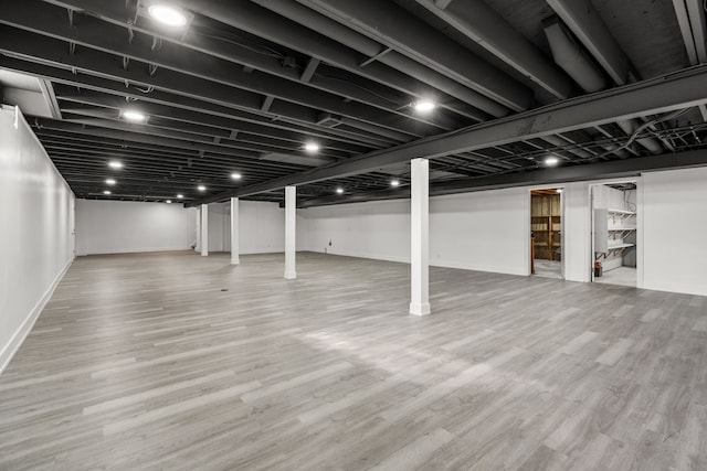 finished basement featuring wood finished floors and baseboards