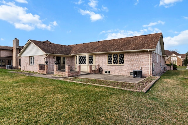 back of house with brick siding, a yard, central AC, and a patio
