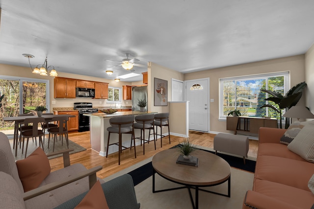 19737 Clement Rd, Northville, MI 48167 - living room with light wood-type flooring, baseboards, a chandelier, and a ceiling fan