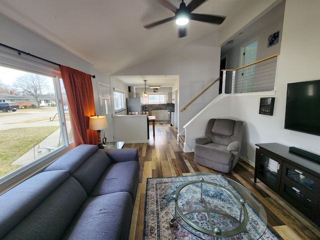living room with stairway, lofted ceiling, wood finished floors, and ceiling fan