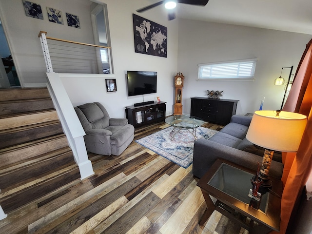 living room with stairway, lofted ceiling, wood finished floors, and ceiling fan
