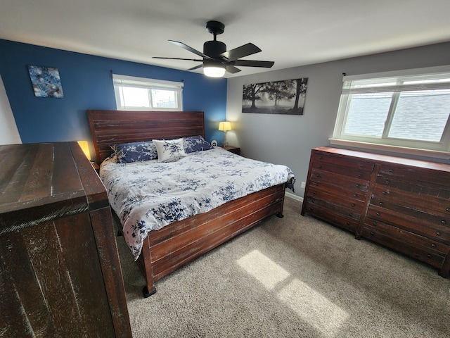 carpeted bedroom with a ceiling fan and baseboards