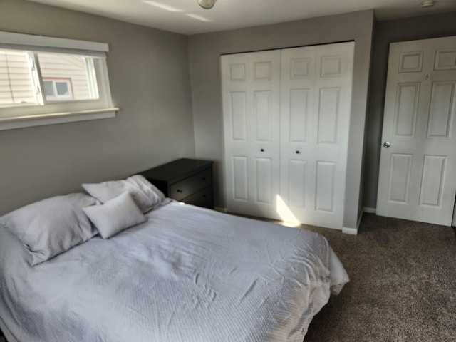carpeted bedroom with a closet and baseboards