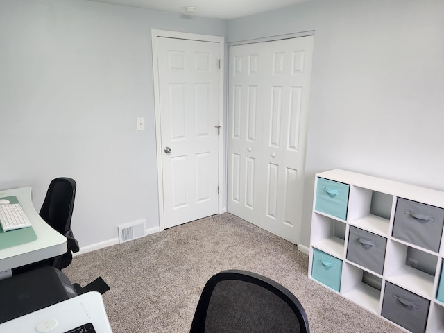 unfurnished office with baseboards, visible vents, and carpet flooring
