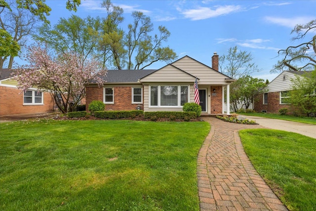 view of front of house featuring brick siding, a chimney, and a front lawn