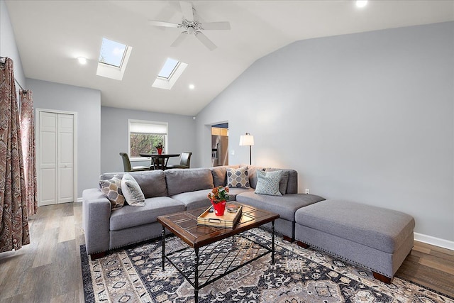 living area with recessed lighting, ceiling fan, lofted ceiling with skylight, and wood finished floors