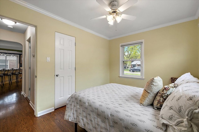 bedroom featuring baseboards, ornamental molding, a ceiling fan, and dark wood finished floors