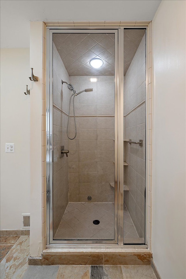 bathroom with baseboards and a shower stall