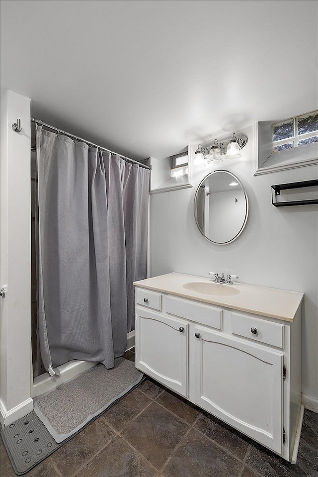 full bathroom with vanity, baseboards, and curtained shower