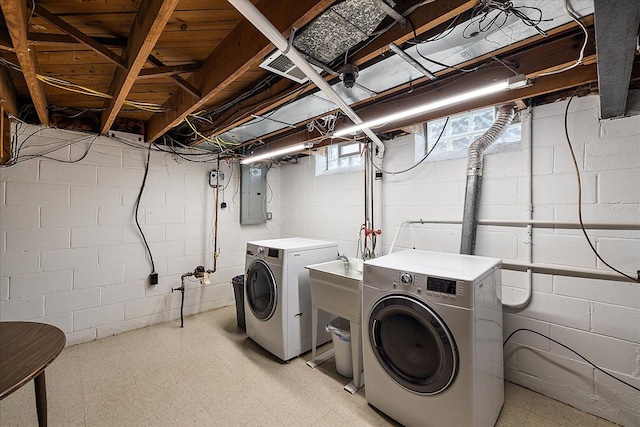 laundry room featuring electric panel, light floors, laundry area, and washing machine and clothes dryer