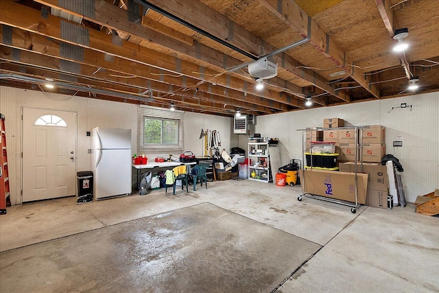 below grade area featuring freestanding refrigerator, a garage, and a workshop area