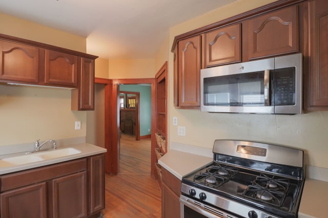 324 Albany St, Ferndale, MI 48220 - kitchen with appliances with stainless steel finishes, a sink, wood finished floors, and light countertops