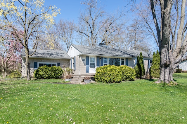 view of front facade with a chimney and a front yard