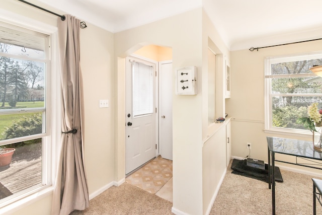 entryway featuring light carpet and baseboards