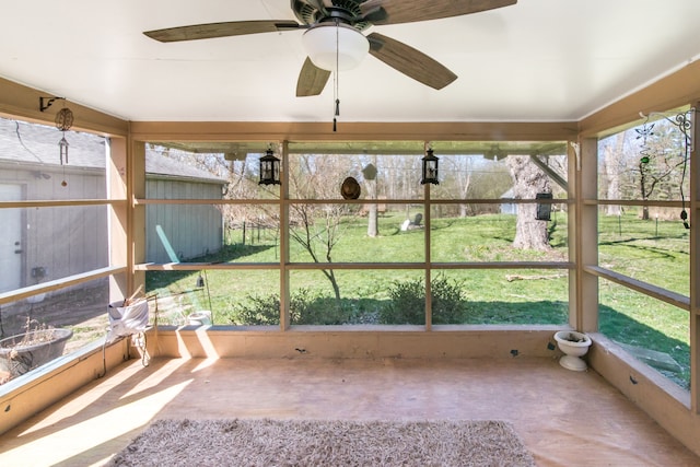 unfurnished sunroom with ceiling fan