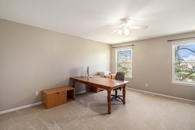 home office with plenty of natural light, light colored carpet, and visible vents