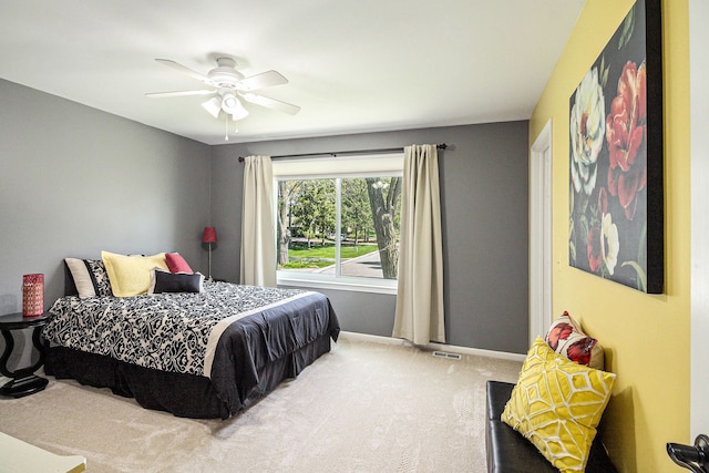 carpeted bedroom featuring baseboards, a ceiling fan, and visible vents