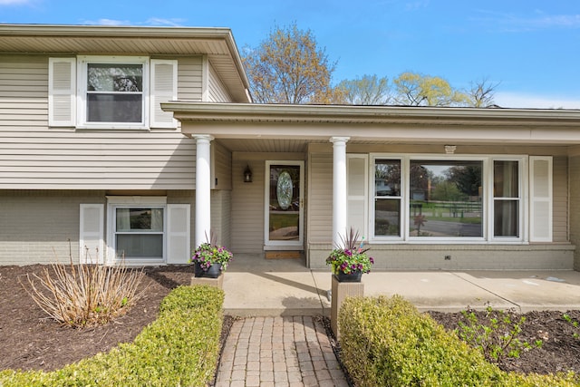 property entrance with covered porch and brick siding