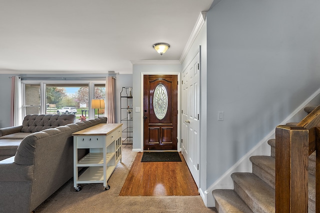 carpeted entrance foyer with ornamental molding and stairway