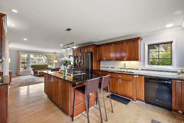 kitchen with a sink, dishwasher, open floor plan, refrigerator with ice dispenser, and ornamental molding