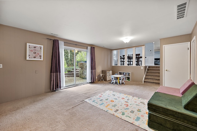 living area featuring carpet, stairs, and visible vents