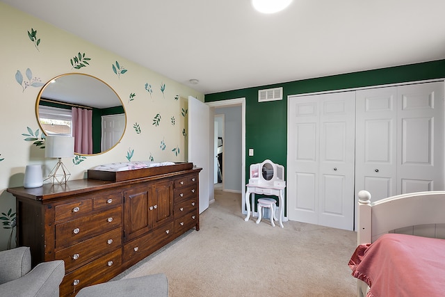 bedroom featuring a closet, light colored carpet, and visible vents