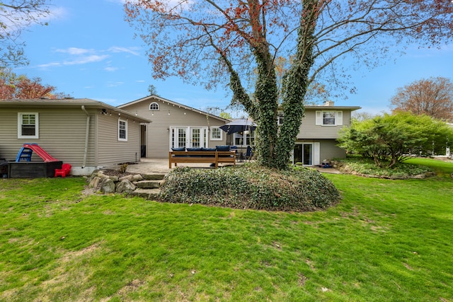 back of house with a lawn, a chimney, and a patio area