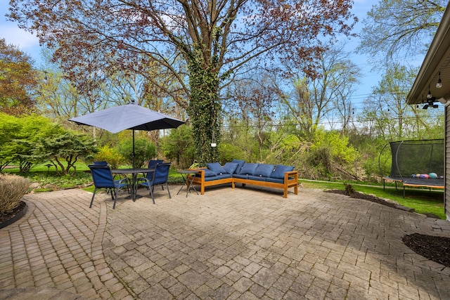 view of patio featuring outdoor dining area, an outdoor hangout area, and a trampoline