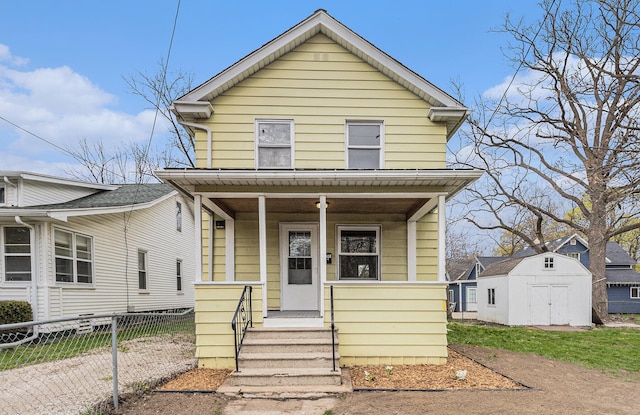 view of front of house featuring an outdoor structure, fence, a porch, and a storage unit