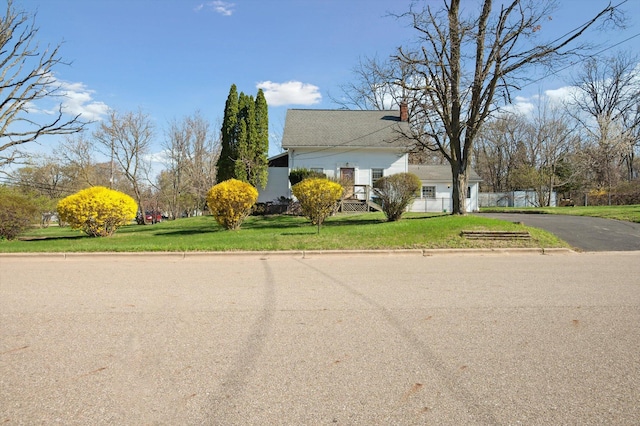 view of side of property with a yard, driveway, and a chimney