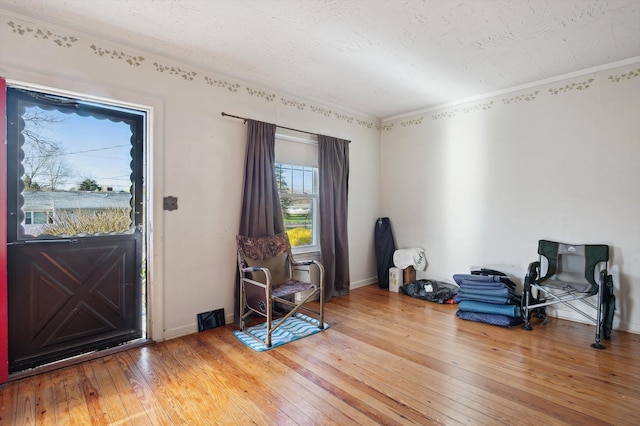 misc room with light wood-style flooring, crown molding, and baseboards