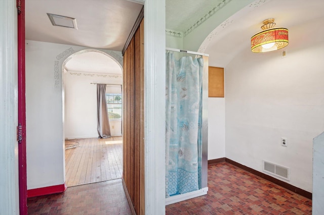 bathroom featuring a shower, baseboards, and visible vents