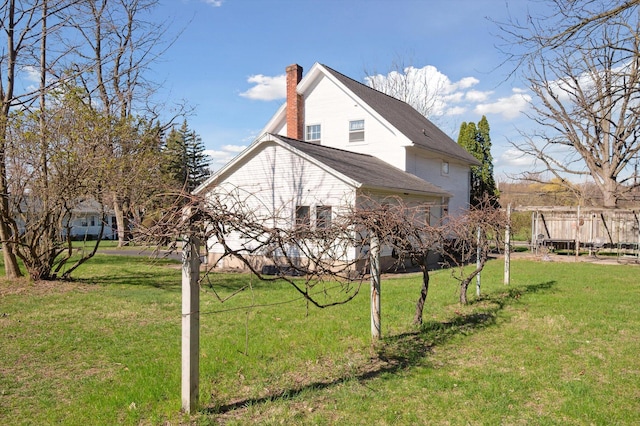 view of property exterior with a lawn and a chimney