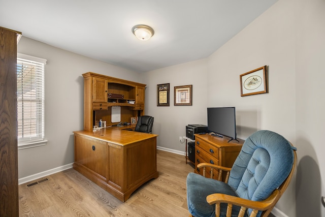 home office with a wealth of natural light, light wood-style floors, visible vents, and baseboards