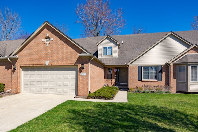 view of front of house with roof with shingles, a front lawn, driveway, brick siding, and an attached garage