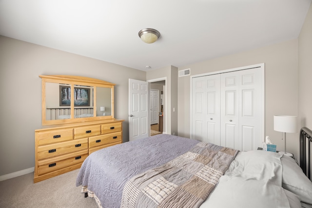 bedroom with baseboards, visible vents, a closet, and light colored carpet