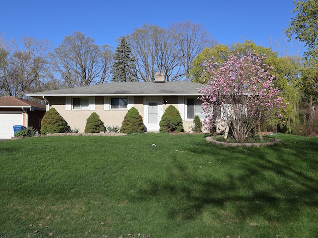 ranch-style home featuring brick siding, a chimney, a front yard, and a garage