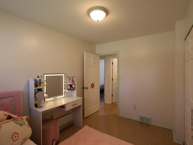 bedroom with visible vents, baseboards, and light wood-type flooring