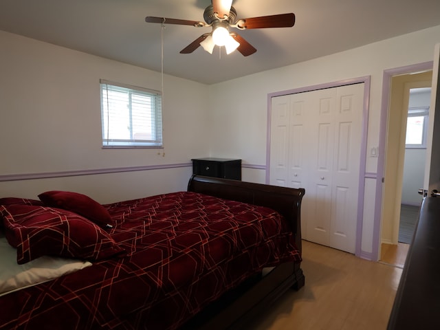 bedroom with light wood-type flooring, a ceiling fan, and a closet
