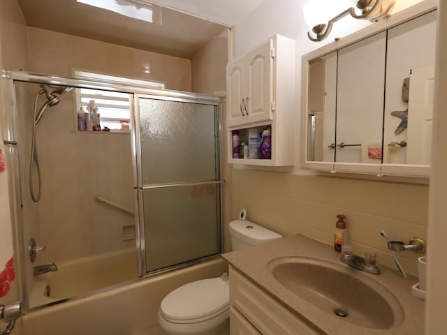 full bathroom with vanity, combined bath / shower with glass door, and toilet