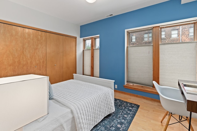 bedroom featuring light wood finished floors, a closet, and visible vents