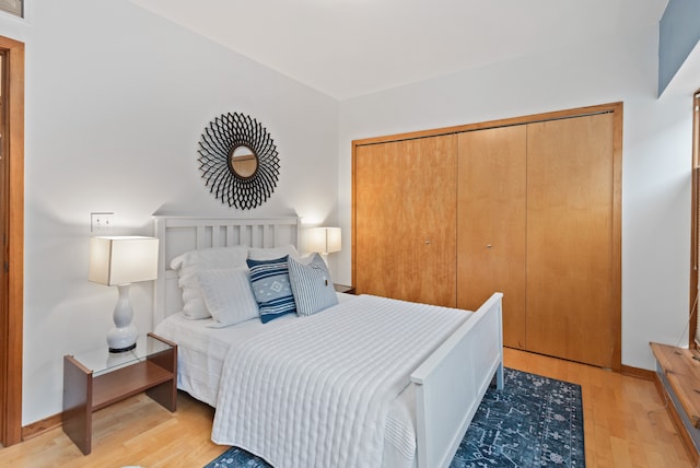 bedroom featuring light wood-style floors, a closet, and baseboards