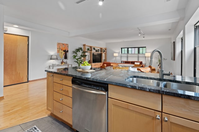 kitchen featuring a sink, light tile patterned floors, dark stone countertops, dishwasher, and open floor plan