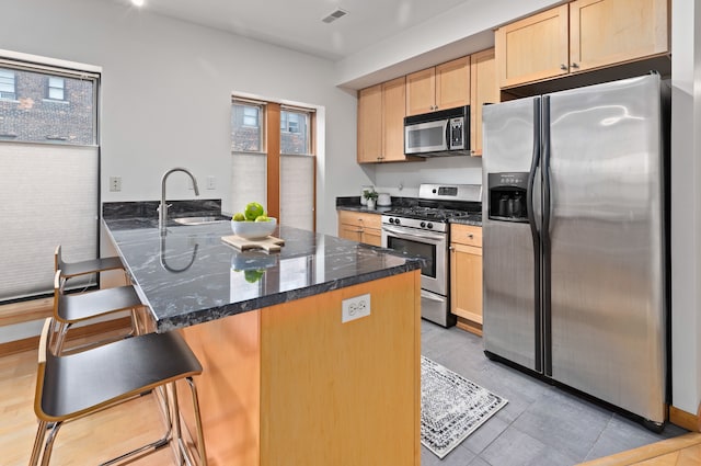 kitchen with light brown cabinets, visible vents, stainless steel appliances, and plenty of natural light