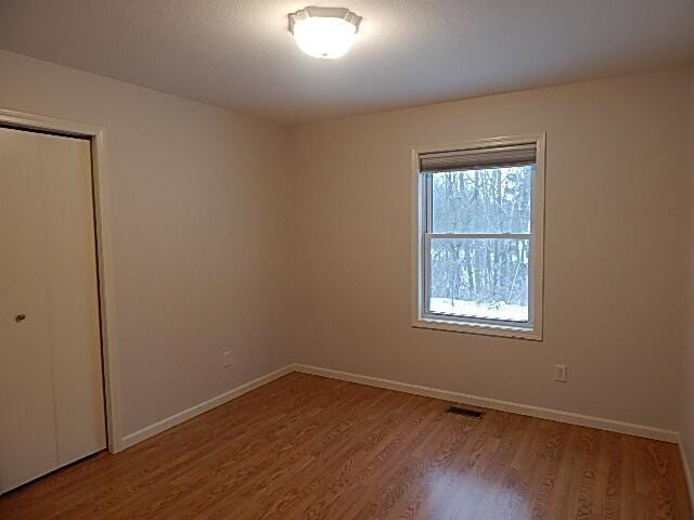 spare room featuring wood finished floors and baseboards