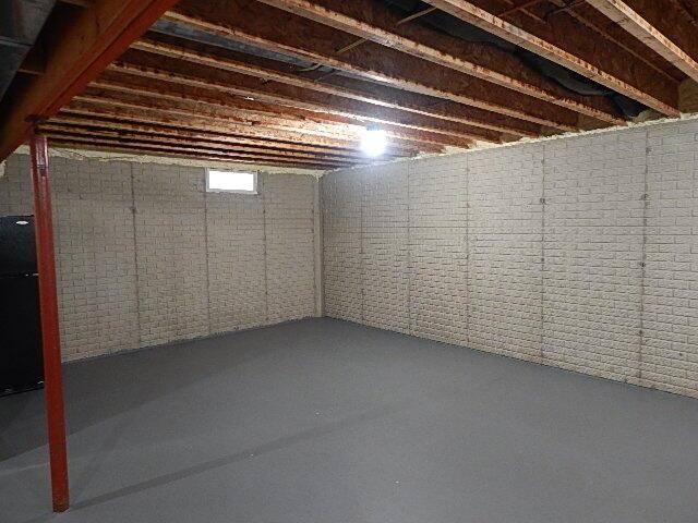 unfinished below grade area with freestanding refrigerator