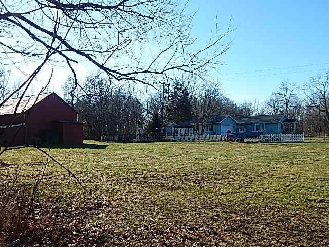 view of grassy yard with a barn and an outdoor structure